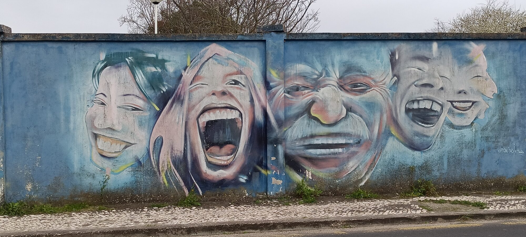 Five laughing faces in a row — Street art in Lisboa