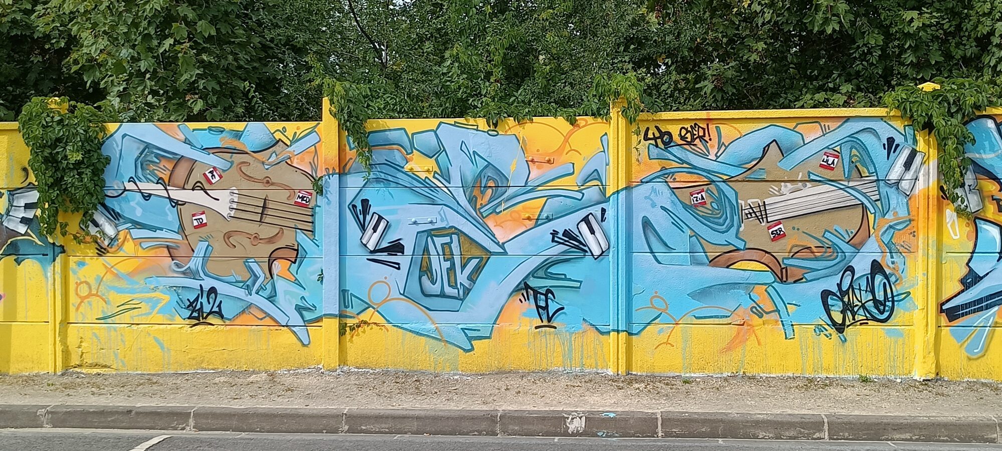 Contrebasses et lettrage bleu par Jek — Street art à Reims