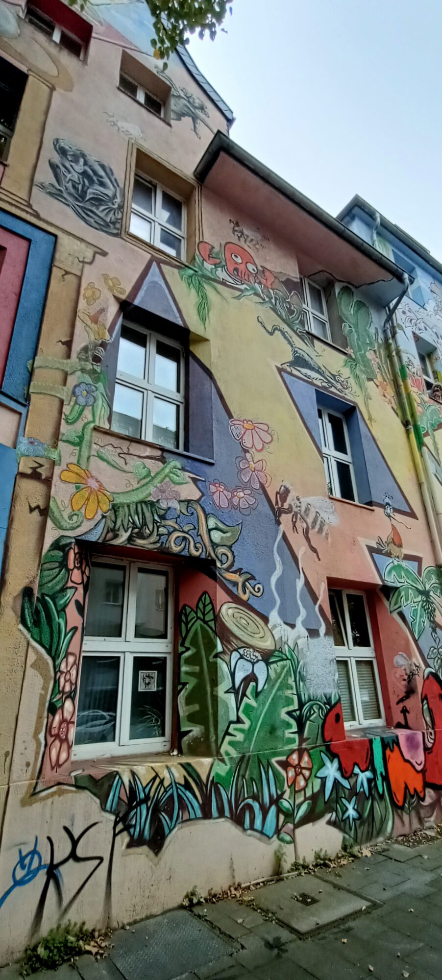 Schöner Wohnen, the red octopus in the jungle — Street art by Klaus Klinger in Düsseldorf