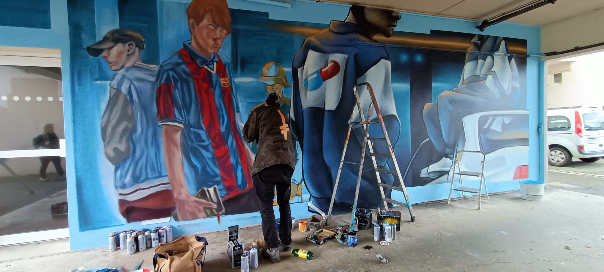 Three blue figures under the porch — Street art in Paimpol