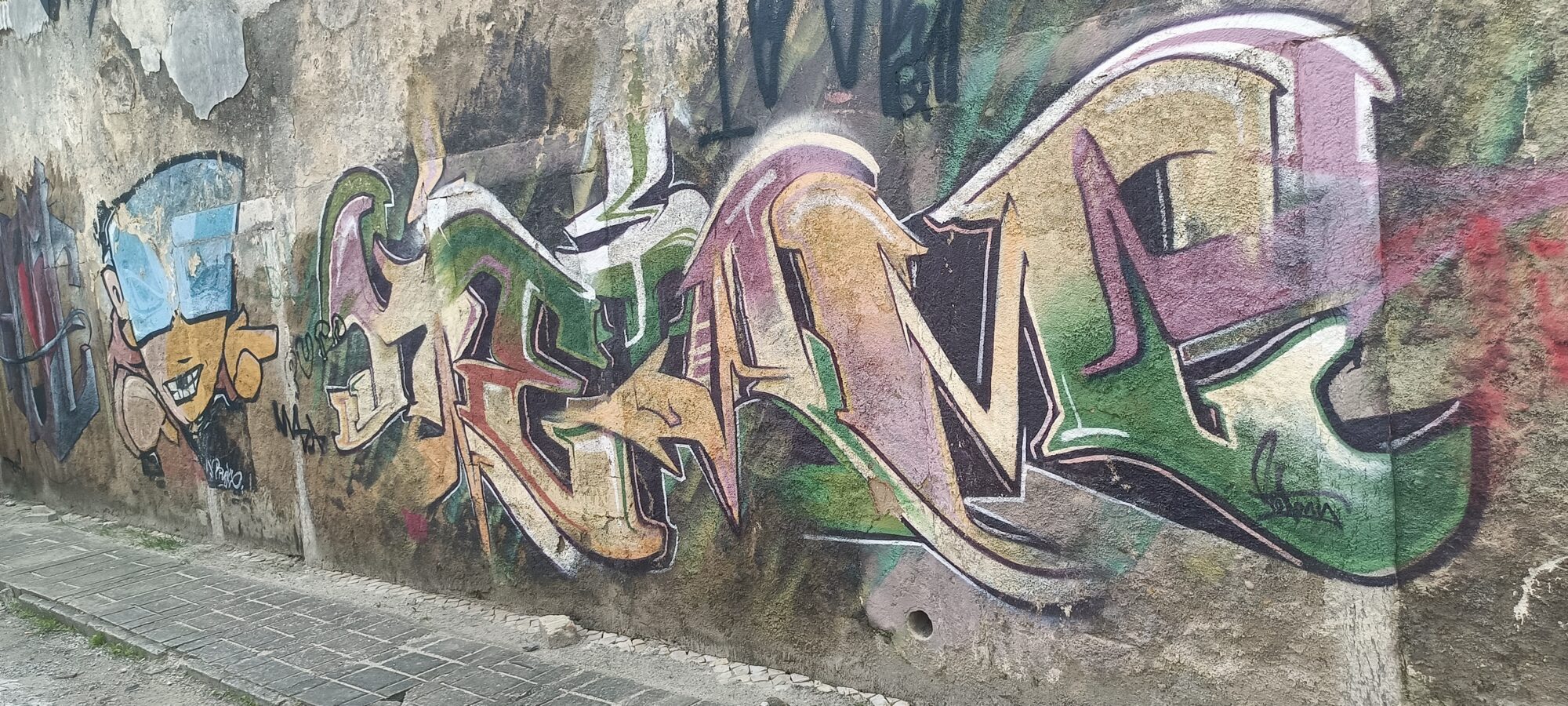 Weathered Green and Ochre Lettering — Street art in Almada
