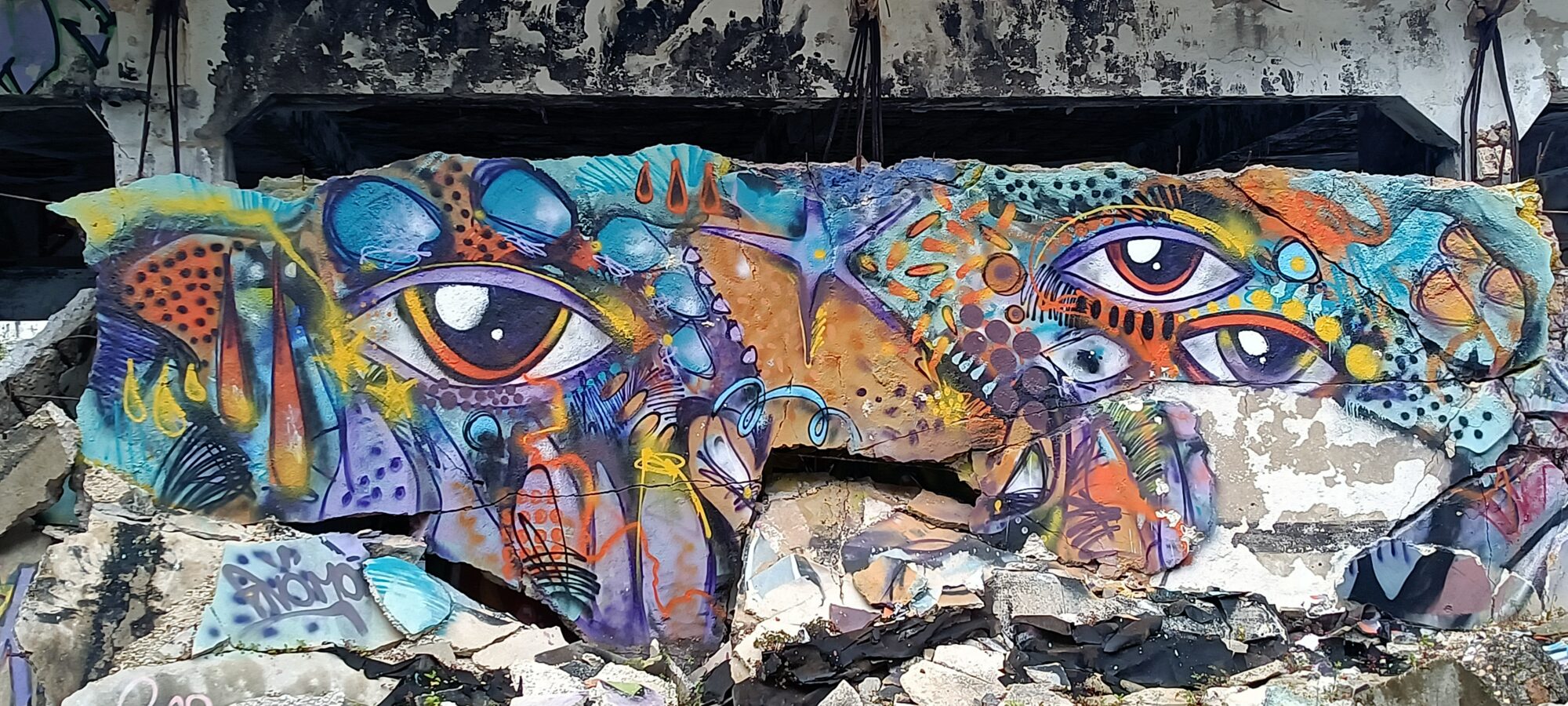 Fresque aux yeux multiples sur dalle effondrée — Street art à Lisboa