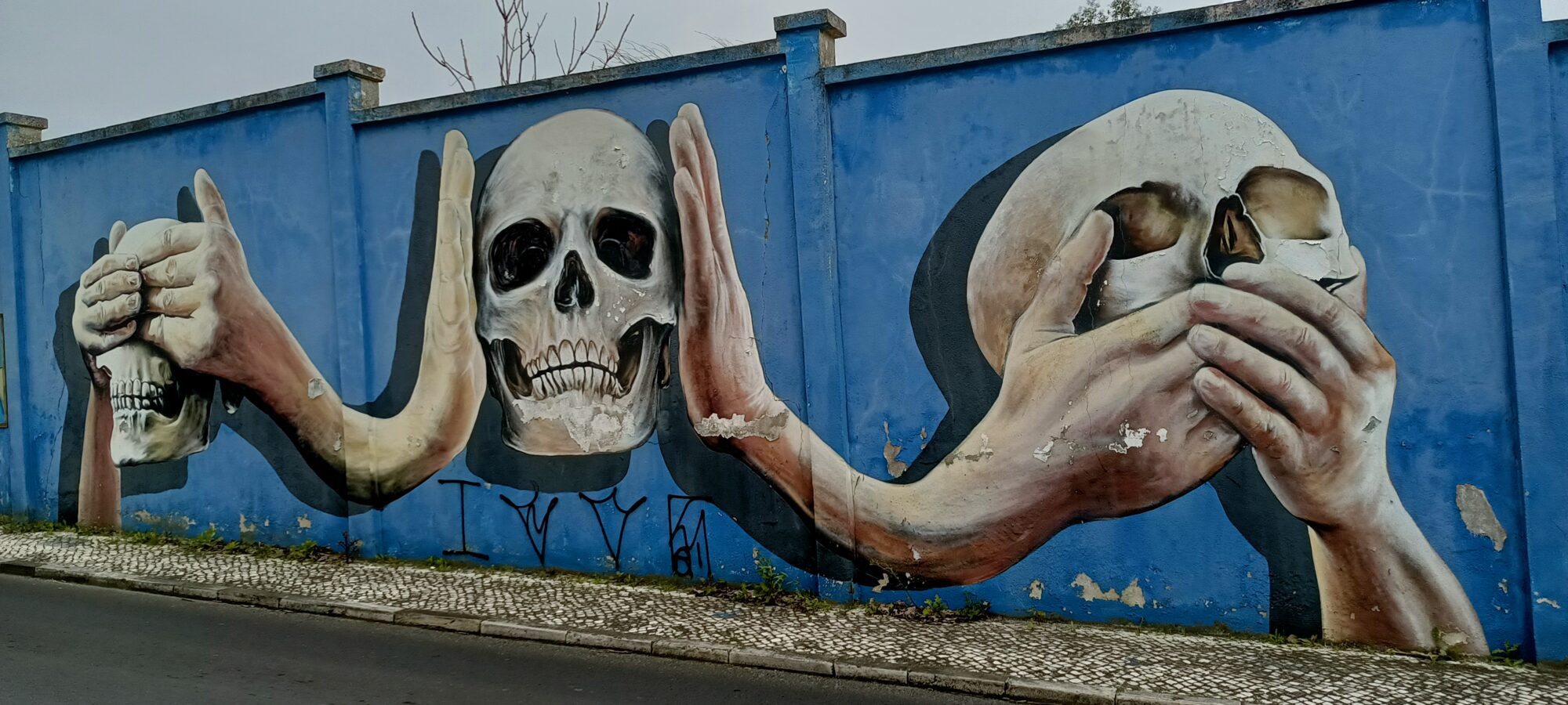 Hands holding skulls — Street art in Lisboa