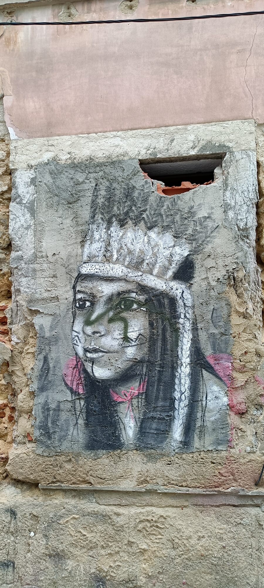 Young Girl in a Feather Headdress — Street art by Rosarlette Meirelles in Almada