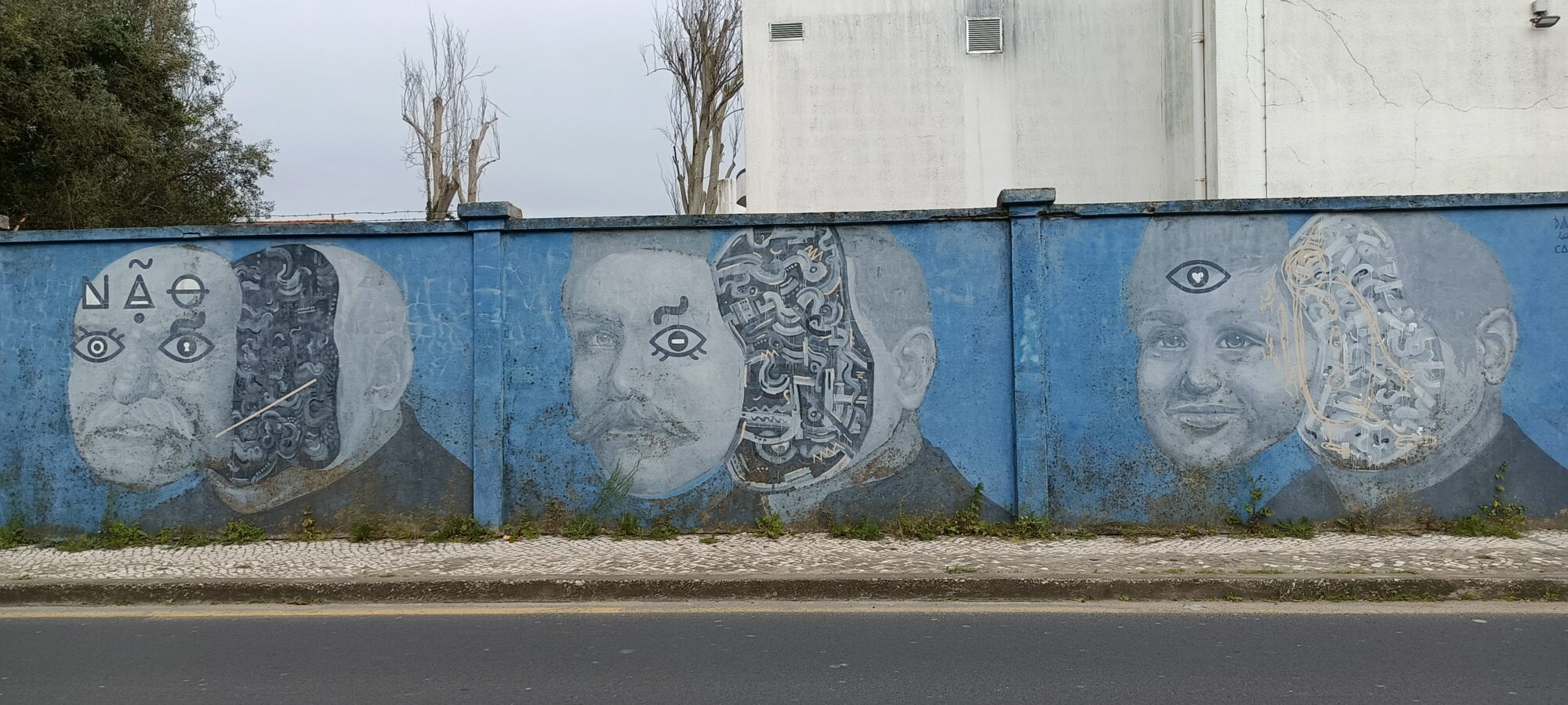 Three faces unravelling into machinery — Street art in Lisboa