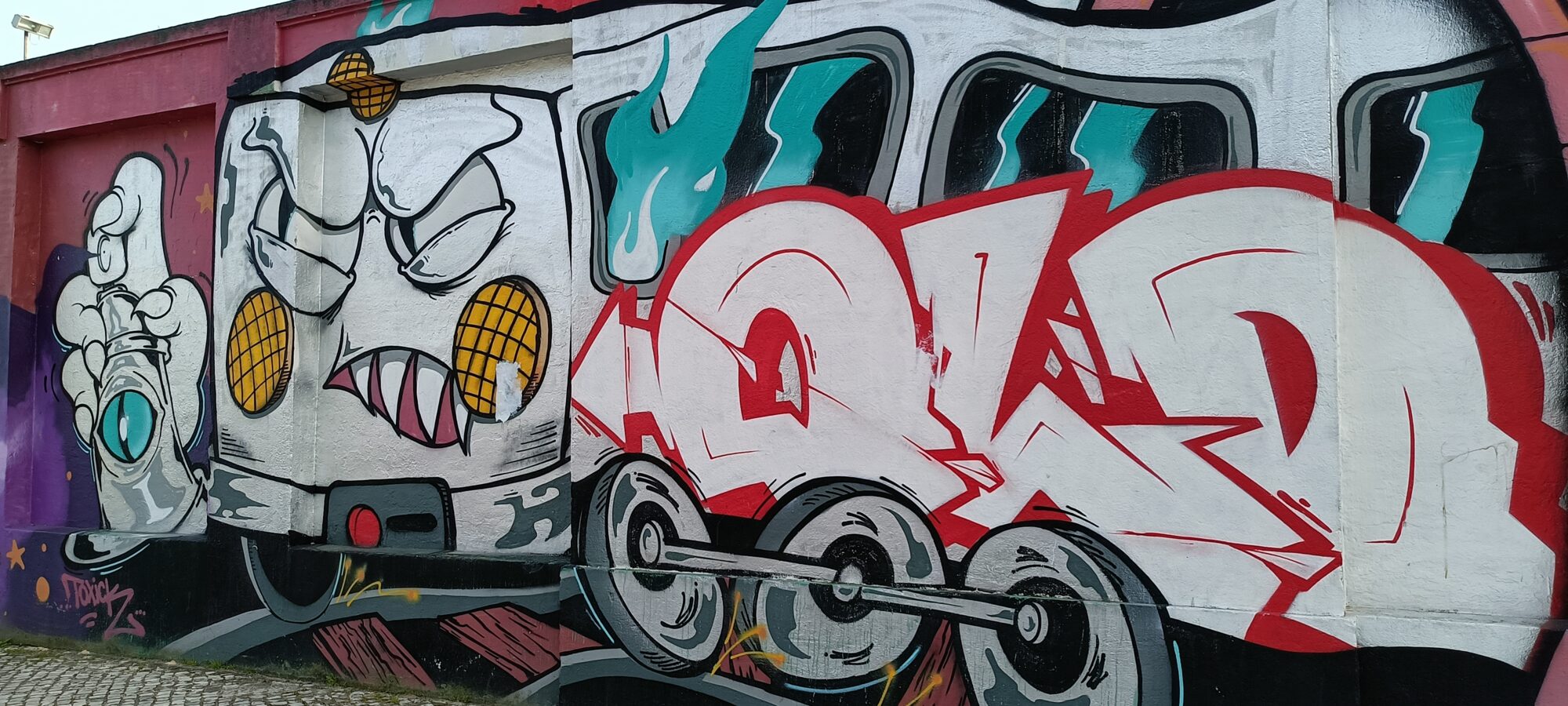 Locomotive grimaçante et lettrage rouge — Street art de Colectivo RUA à Lisboa
