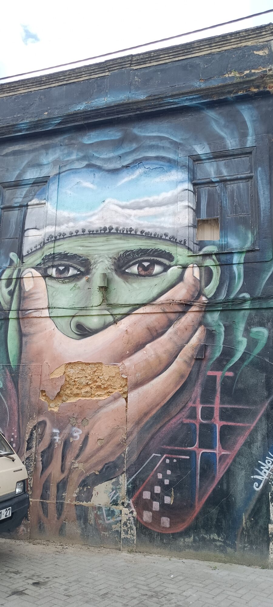 Silenced Green Face and Caravel — Street art in Almada