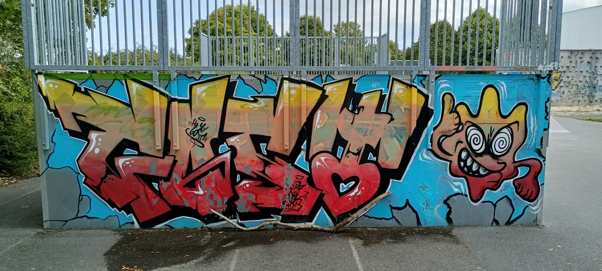 Yellow lettering at the skatepark — Street art in Yffiniac