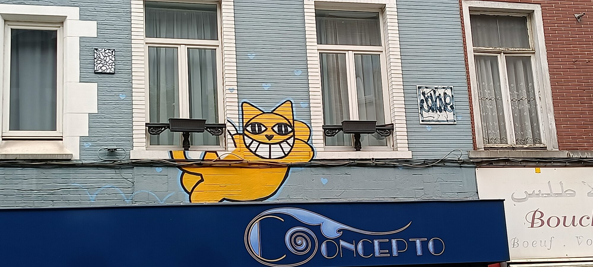 M. Chat's Yellow Cat on Rue Haute — Street art by M. Chat in Bruxelles
