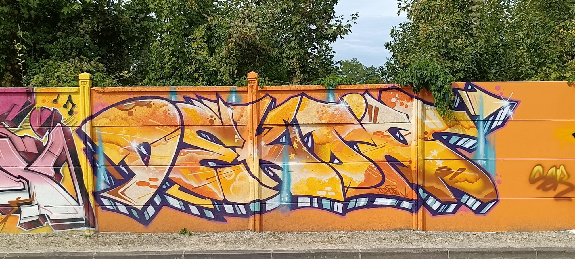Lettrage orange et or aux notes de musique — Street art à Reims