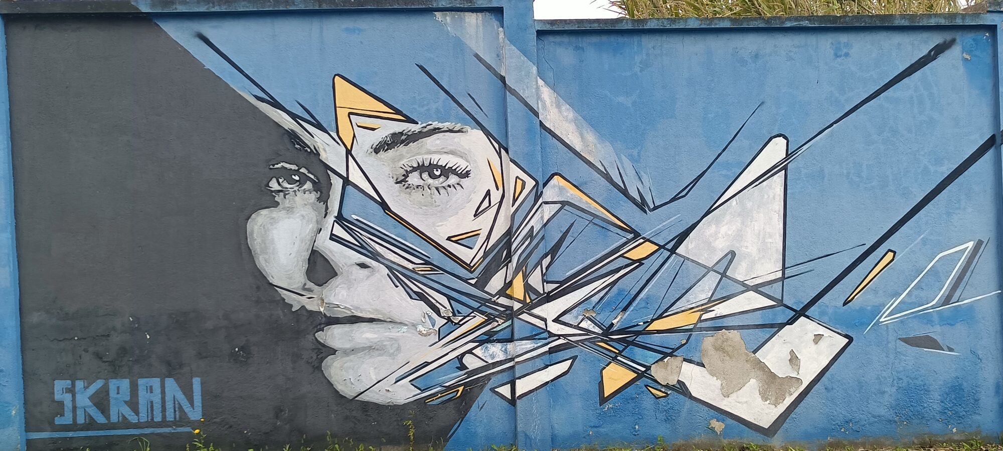 Visage fragmenté en éclats jaunes — Street art de Skran à Lisboa
