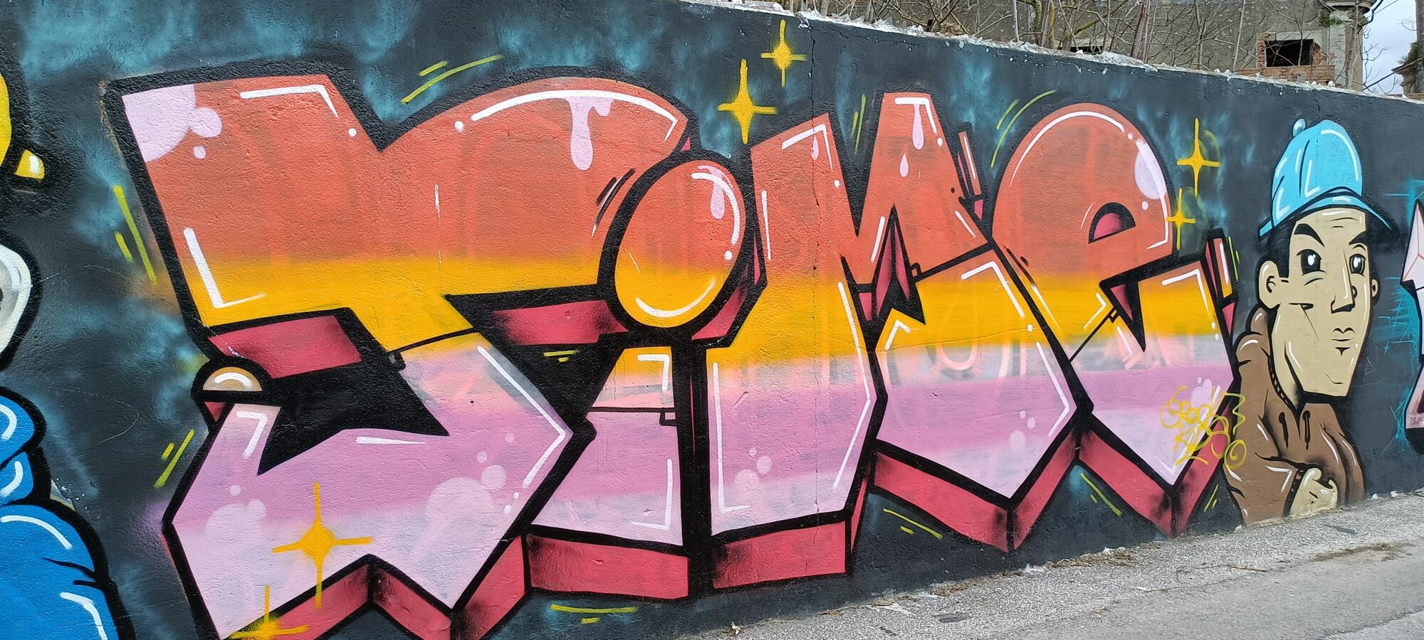 Lettrage orange et rose et homme à la casquette bleue — Street art à Almada