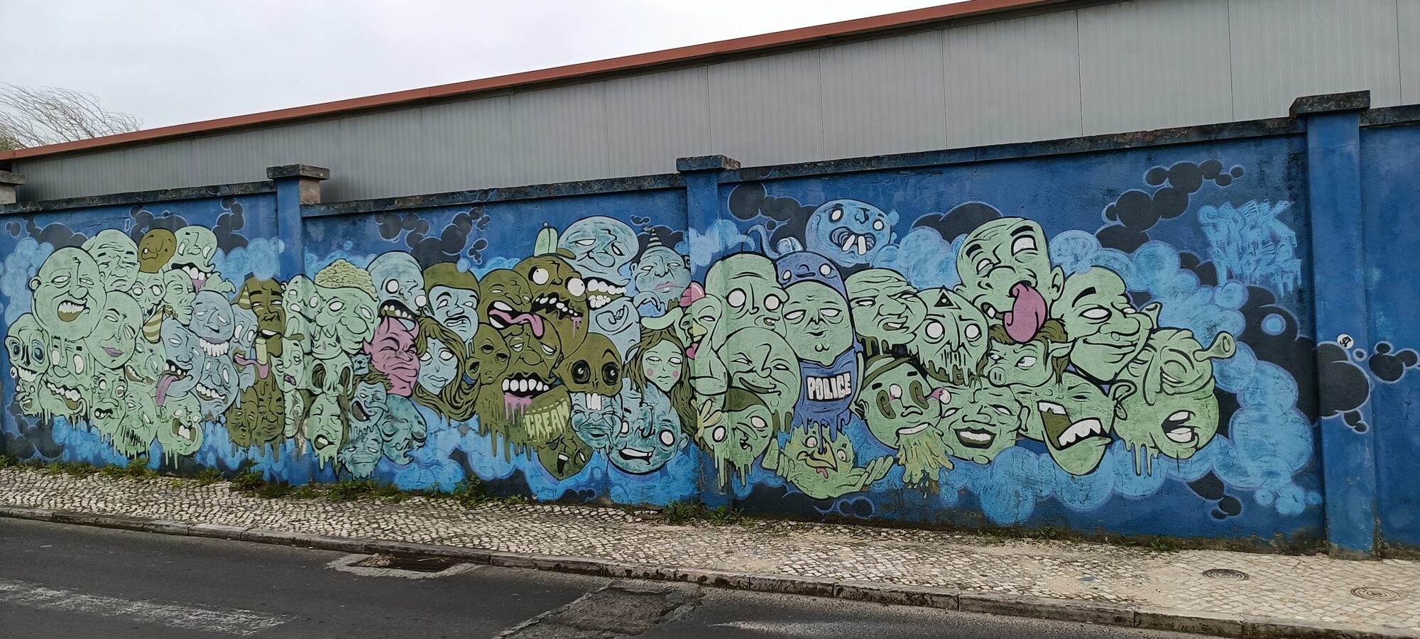 Foule de têtes cartoon empilées — Street art à Lisboa
