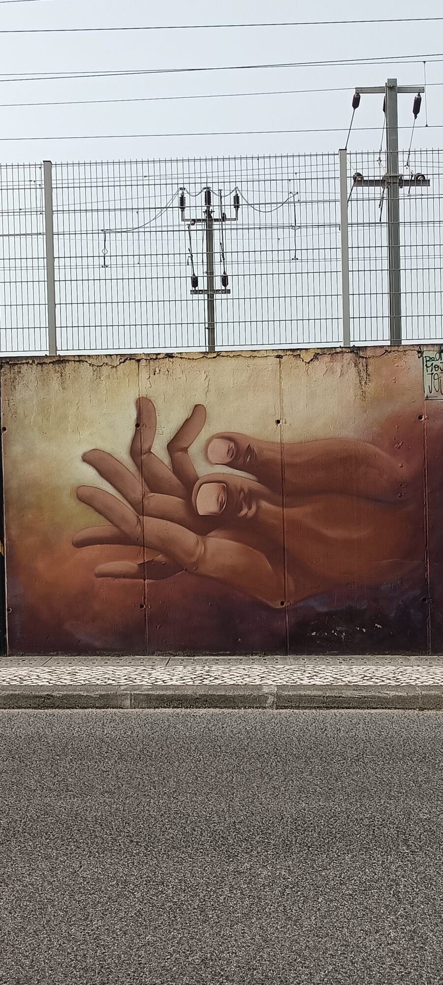 Mains sépia aux visages dans les doigts — Street art de Pedro Mojo Jojo à Lisboa