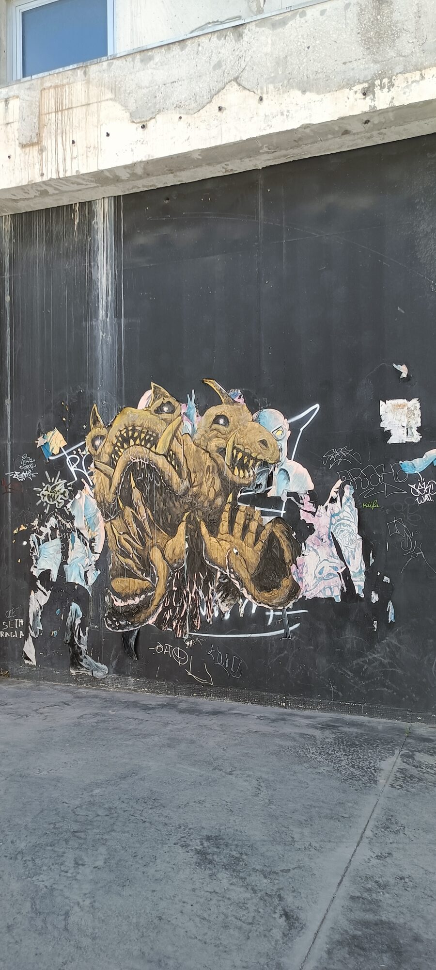 Créature dorée bicéphale sur bardage noir — Street art à Marseille