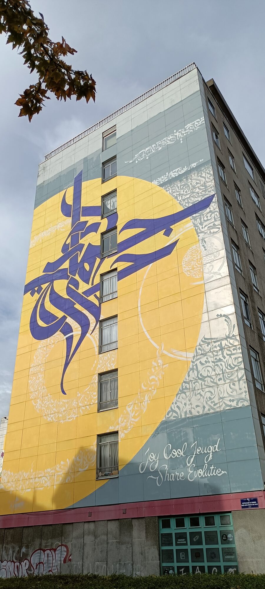 Calligraffiti violet sur soleil jaune — Street art de Dema à Bruxelles