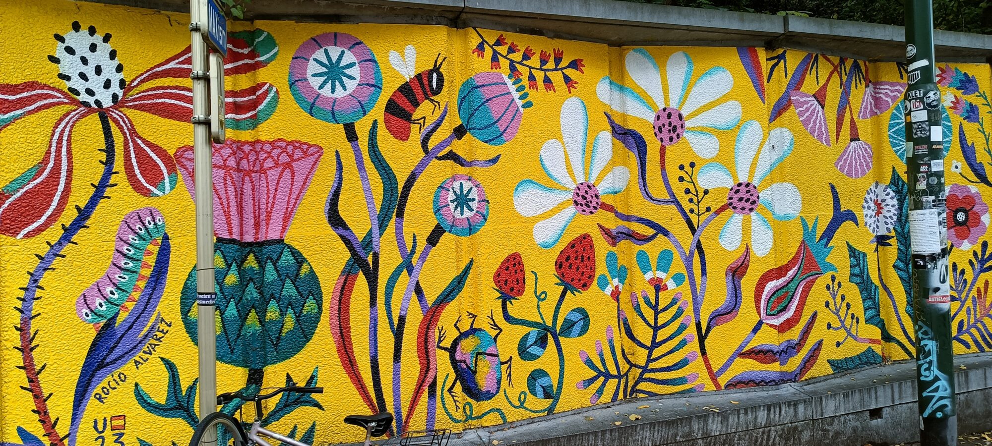 Yellow meadow and pollinators — Street art by Rocío Álvarez in Ixelles