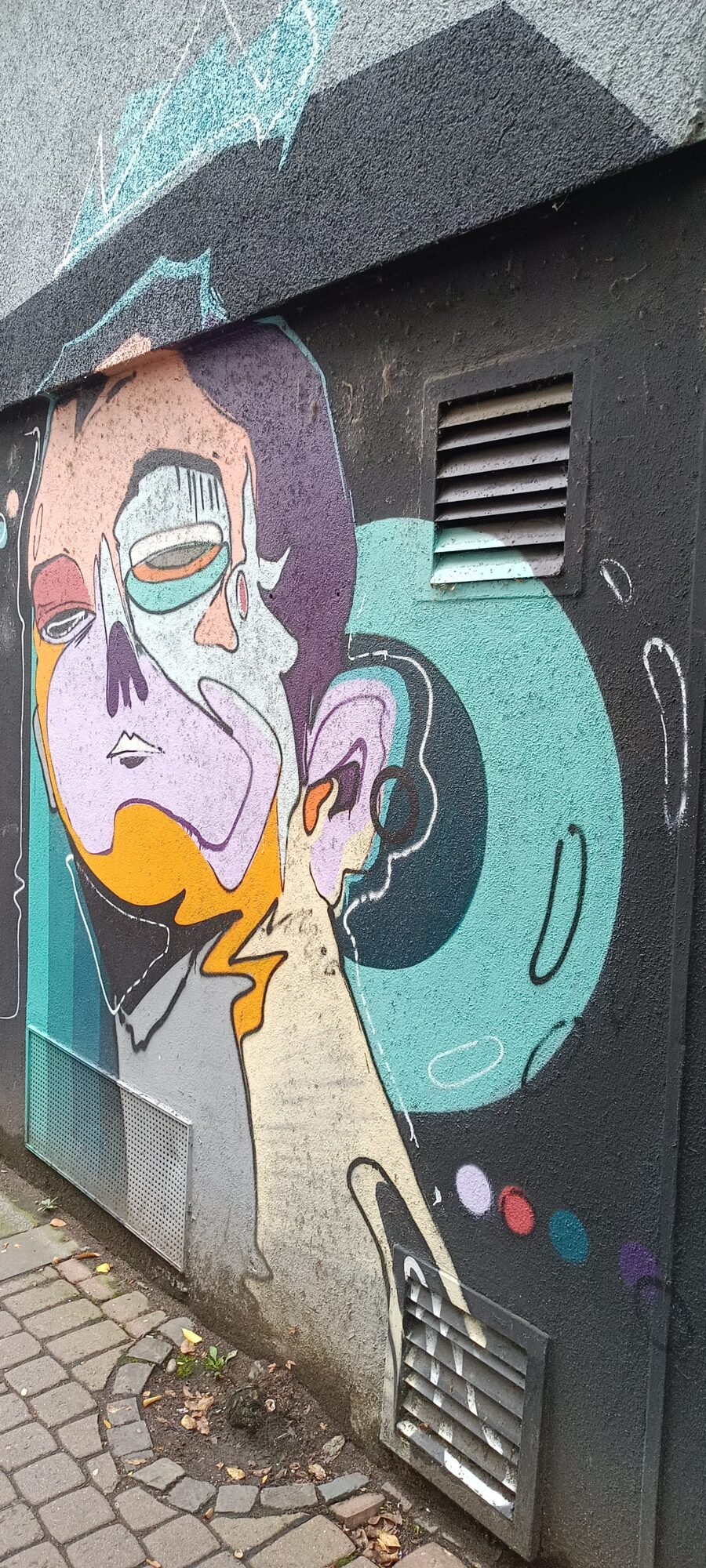 Visage cubiste sur mur noir — Street art à Köln