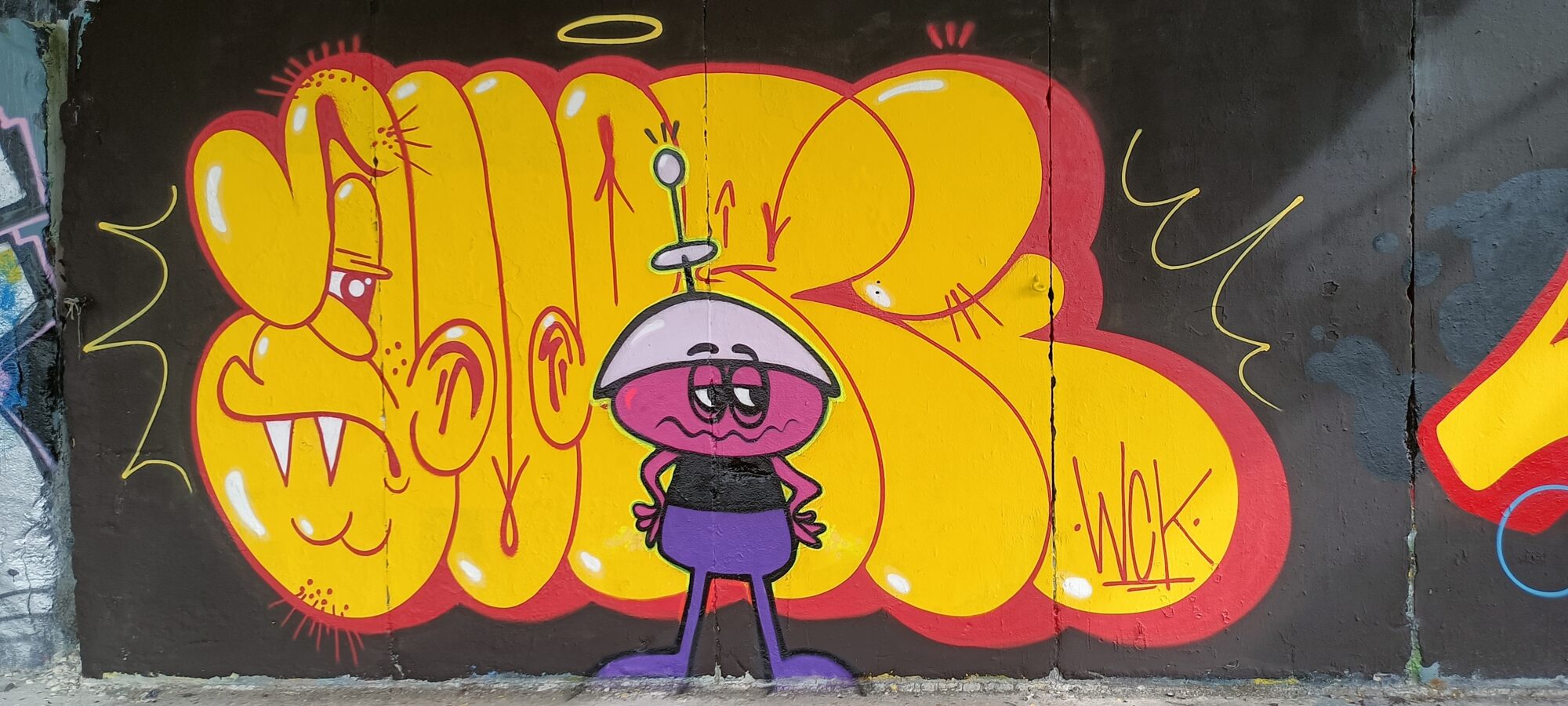 Yellow lettering and little alien — Street art in Plérin