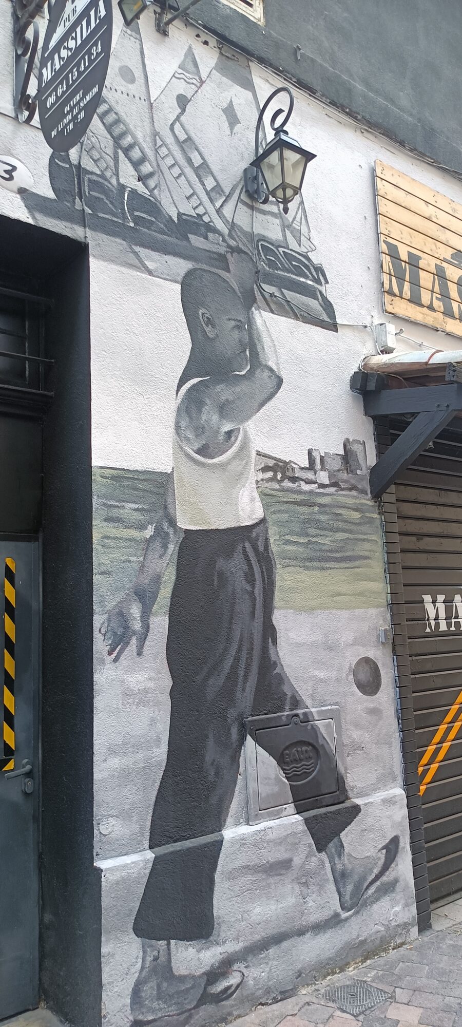 Walker in a tank top before the tall ship — Street art in Marseille