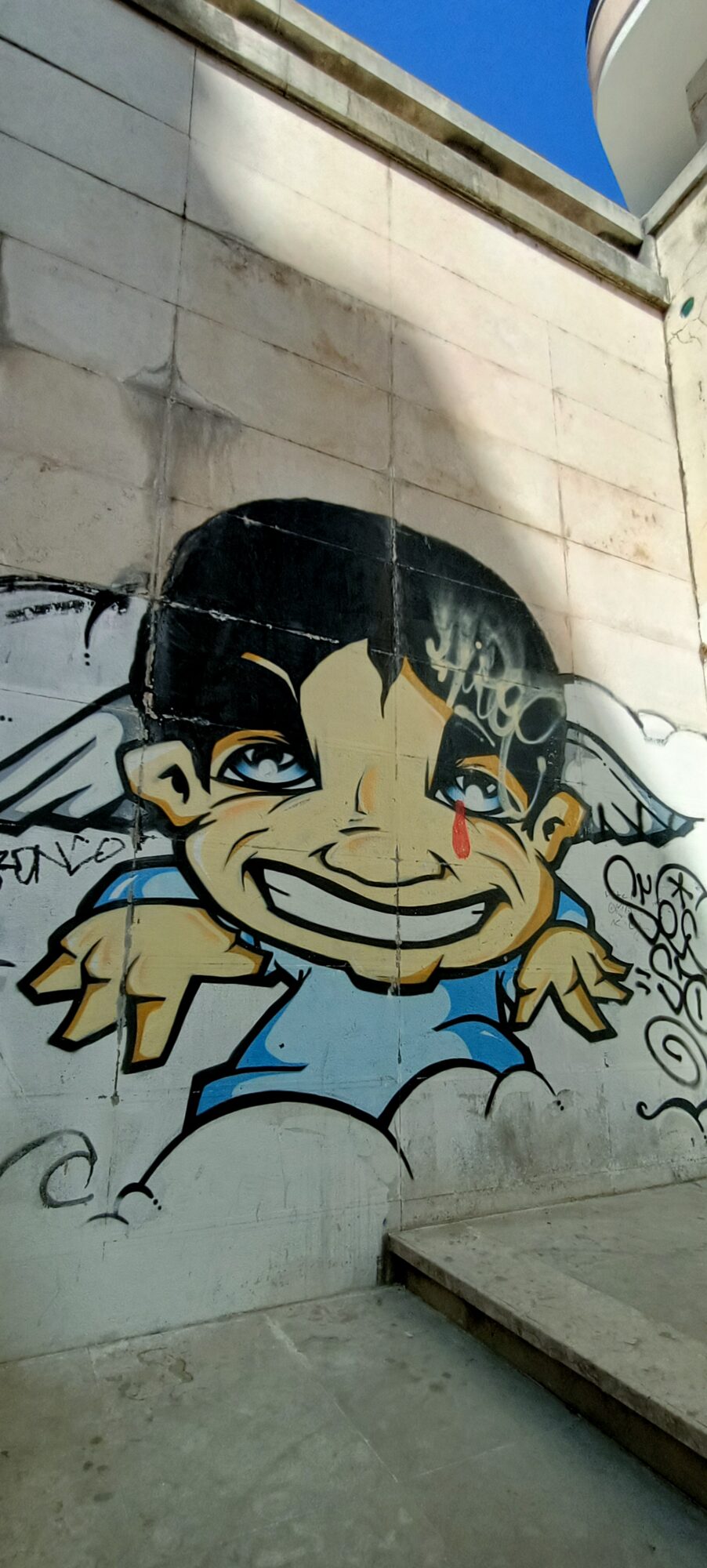 Grinning Cherub with a Red Tear — Street art in Lisboa