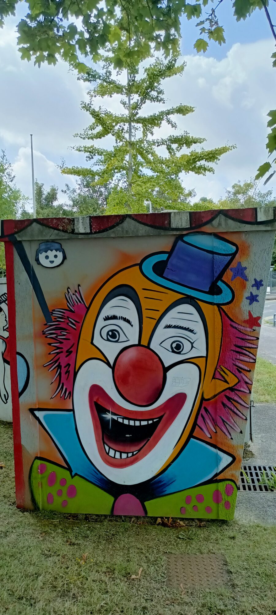 Clown in a blue top hat — Street art in Yffiniac
