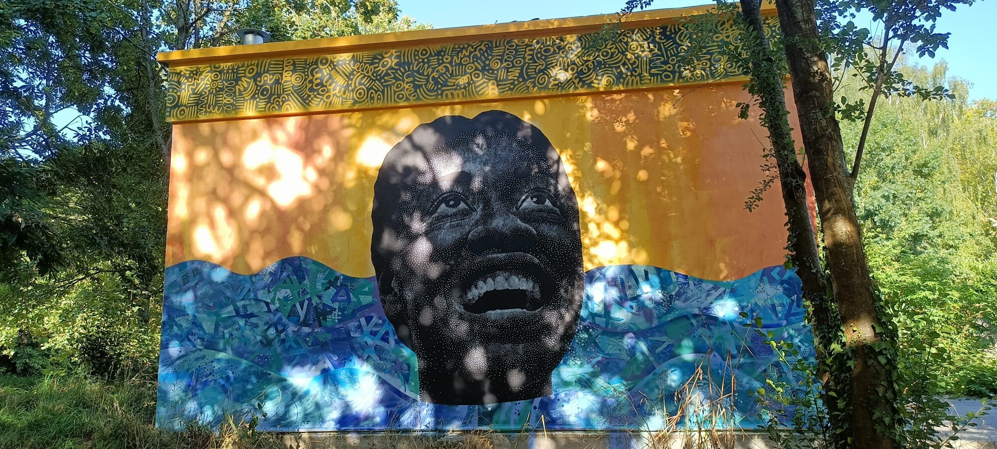Visage pointilliste émergeant de l'eau — Street art de Lady bug à Nantes