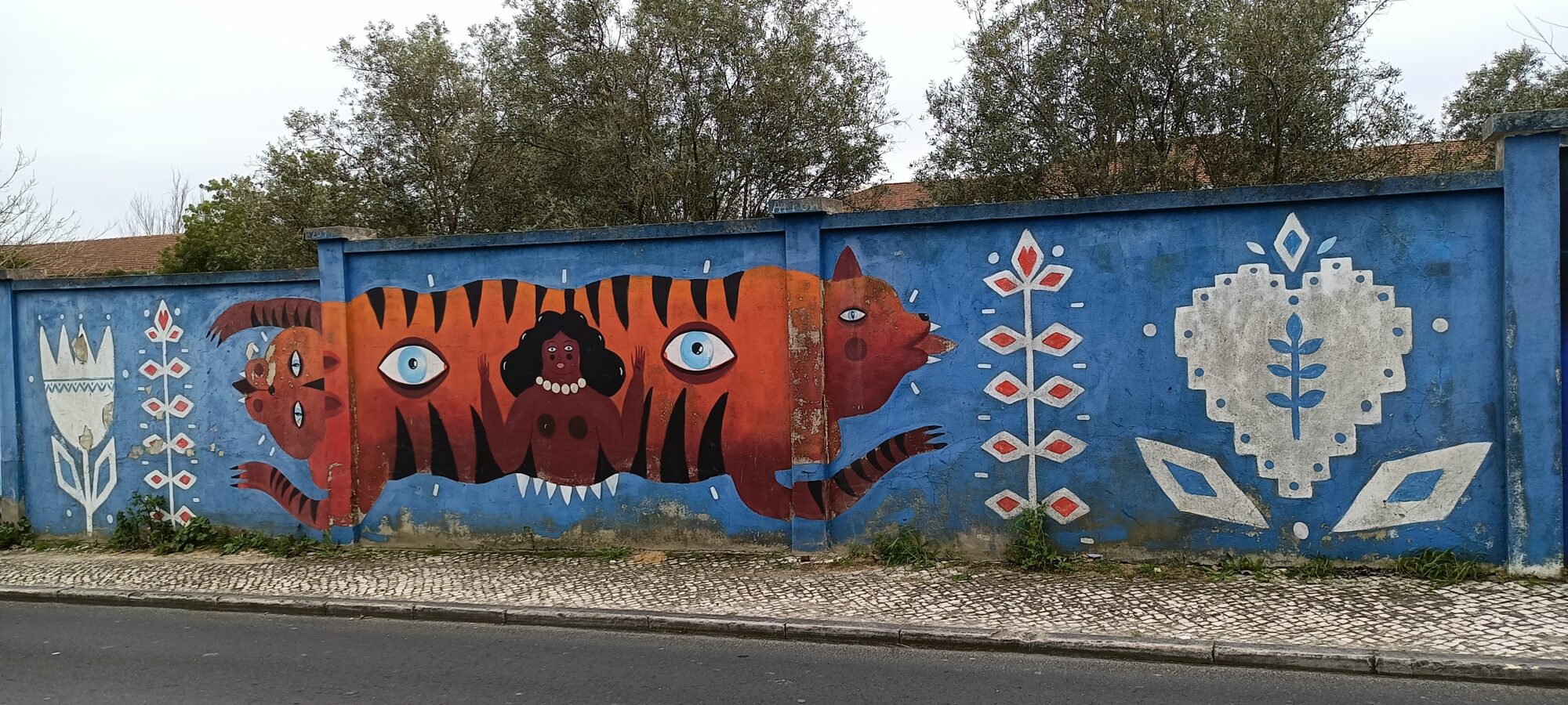 Orange beast with a hidden figure — Street art in Lisboa
