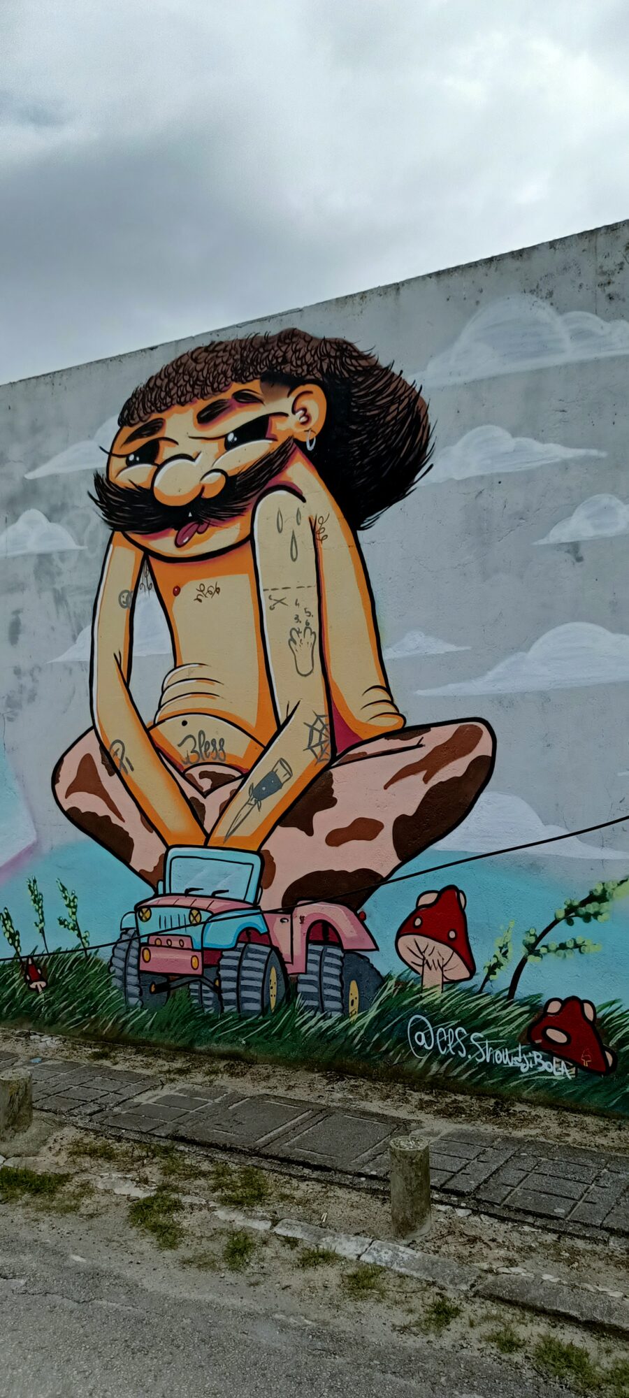 Personnage assis sur un jouet et champignons — Street art à Almada