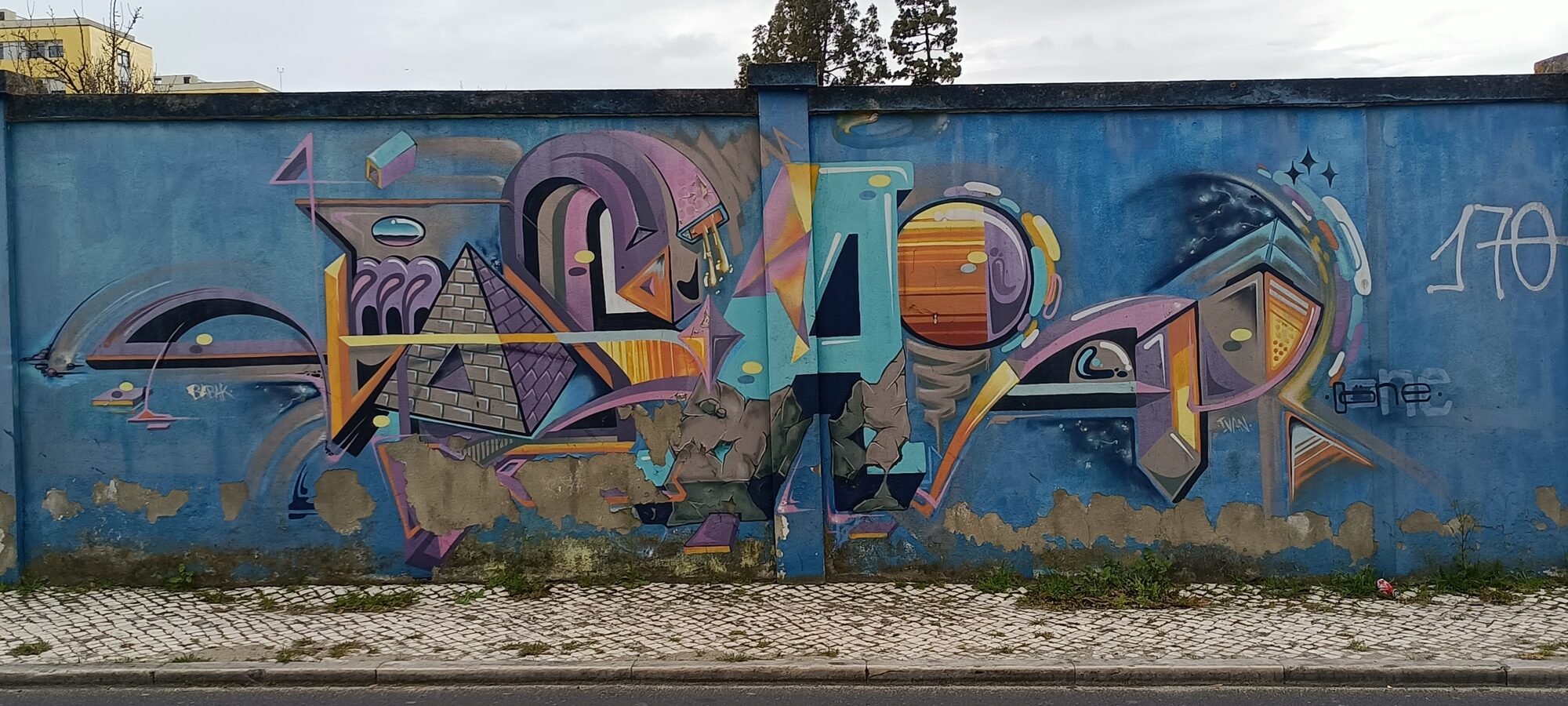 Pyramid and orange planet — Street art by Odeith in Lisboa