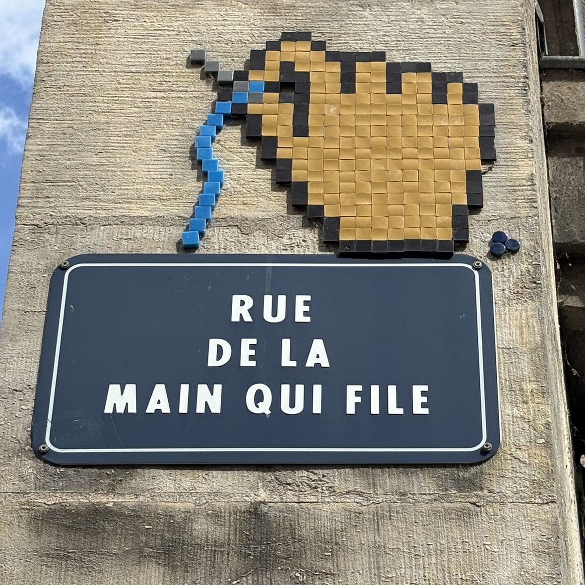 La main qui file son fil bleu — Street art de Mifamosa à Orléans