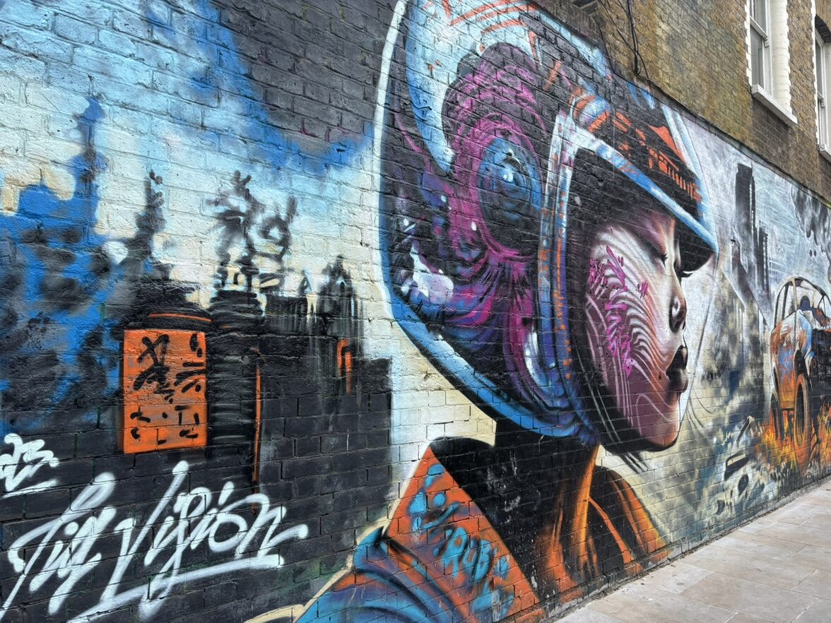 Pilote casquée devant la ville — Street art de Jim Vision à London