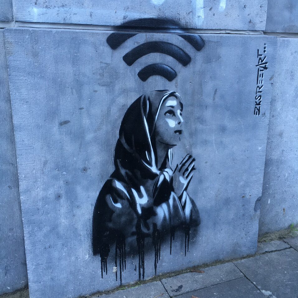 The Praying Figure with a Wi-Fi Halo — Street art by EZKSTREETART in Bruxelles