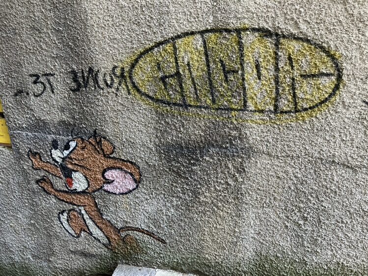 Jerry and his slice of Emmental — Street art by OakOak in Le Locle