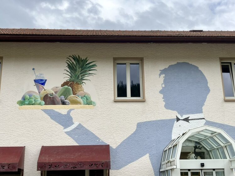 The Waiter with a Tray at Le Chevreuil — Street art by Carolus in La Chaux-de-Fonds