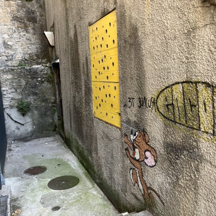 Jerry and his slice of Emmental — Street art by OakOak in Le Locle