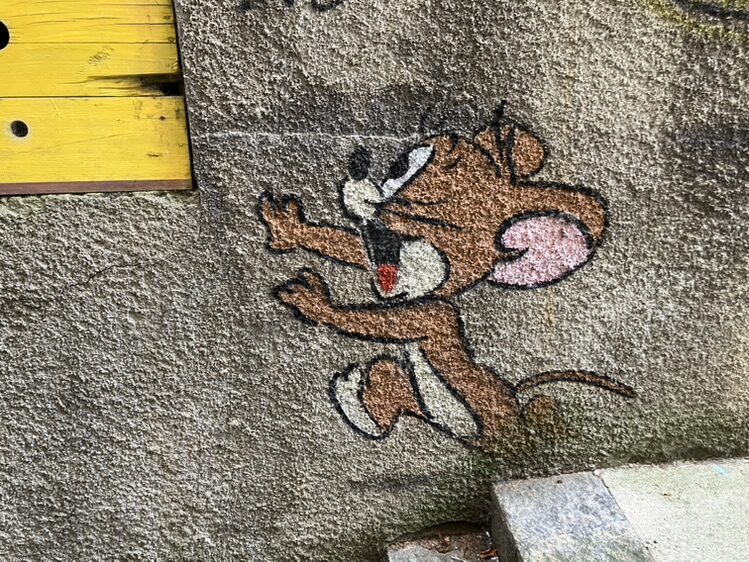 Jerry and his slice of Emmental — Street art by OakOak in Le Locle