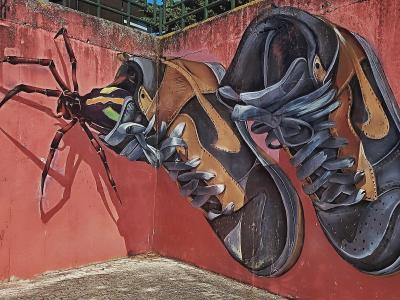 Nike shoes with a spyder pumping out — Street art by Odeith in Amora