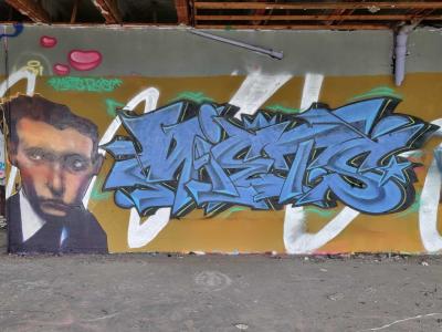Blue lettering and the wide-eyed man — Street art in Grenoble