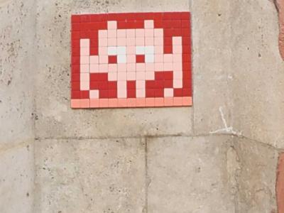 Invader TLS_07, alien carmin sur rouge — Street art de Invader à Toulouse