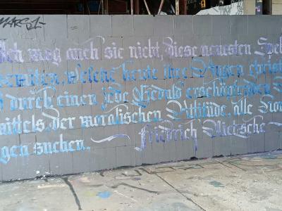 Citation de Nietzsche en calligraphie gothique — Street art de Parisurteil à Berlin