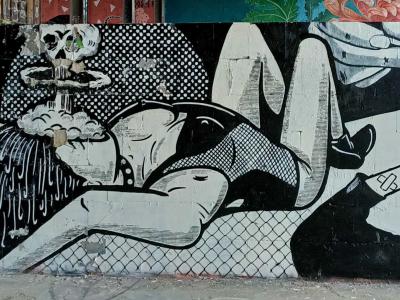 Femme allongée entre crânes et démons, noir et blanc — Street art de ERRE à Berlin