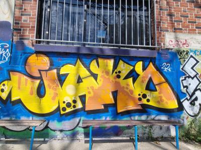 Graffiti en lettres jaunes sur fond bleu — Street art à Strasbourg