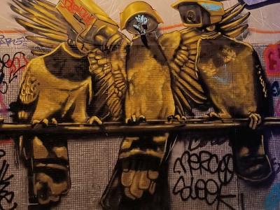 Trio de faucons urbains perchés sur une rambarde — Street art à Paris