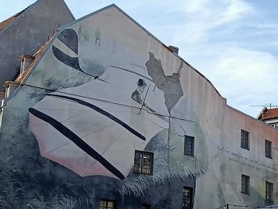 Funambule au chapeau melon dans les nuages — Street art à Rīga