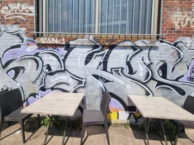 Graffiti wildstyle argenté sur fond violet — Street art à Strasbourg
