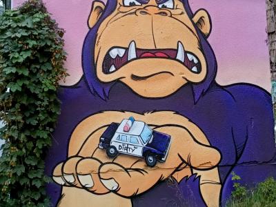 Gorille géant et voiture de police, cartoon — Street art de Dirty Dog à Berlin