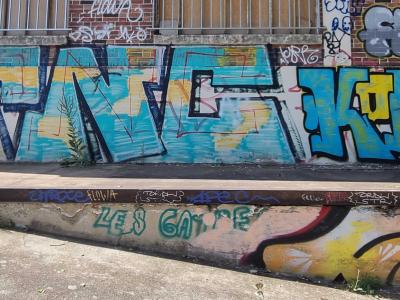 Tags superposés en bleu et teal — Street art à Strasbourg
