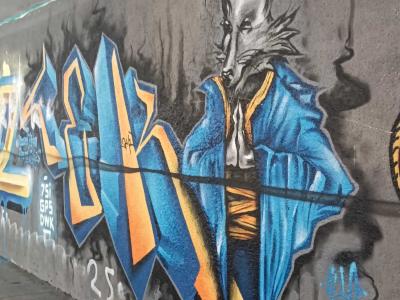 Dressed Wolf and Blue Orange Graffiti — Street art in Prague