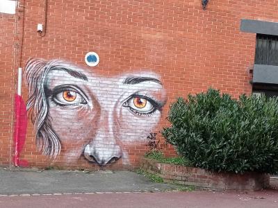 Yeux de femme sur brique lilloise — Street art à Lille
